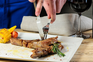 steak meat in a white plate being cut with a knife