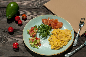 breakfast scramble with greens and vegetables and salmon in a plate on the table