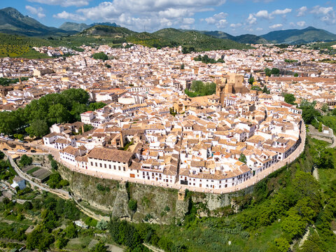 Aerial view of the stark white buildings and the castle standing out against the green landscape, a beautiful contrast of textures and tones, Priego de C&oacute;rdoba, Andalusia, Spain.