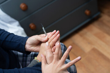 Mom cuts her young son's nails and teaches him how to do it, teaching personal hygiene. Comparison of two hands with trimmed nails and not yet trimmed