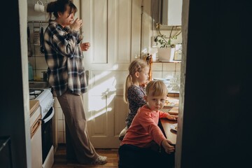 Mother and children enjoying morning at home kitchen