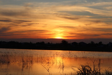 Sunset Serenity: A picturesque scene unfolds as the sun dips below the horizon, painting the sky with fiery hues and casting a golden glow on the tranquil water.