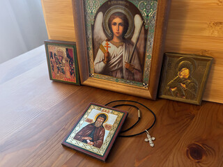Orthodox icons and a cross on a wooden table, dark room