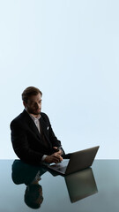 Pensive man in suit using laptop in quiet moment of online casino play. Concept of digital gambling, risk evaluation, betting platforms and emotional decision making.