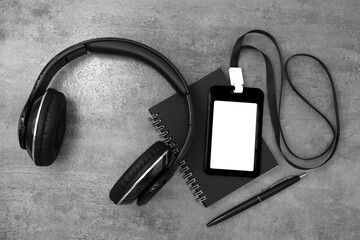 Black plastic badge with book and headphones  on stone texture b