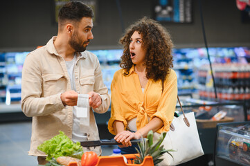 Couple facing high grocery prices in supermarket
