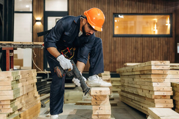 Fototapeta premium Tool for cutting in hands. Male carpenter working with wooden materials in a professional workshop