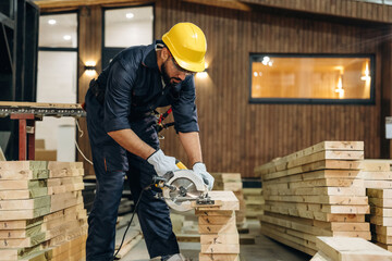 Man is focused, daily job. Male carpenter working with wooden materials in a professional workshop