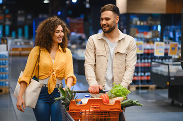 Happy couple grocery shopping together in supermarket