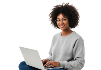 Young african american woman, natural curly hair, stylish gold glasses, typing on a silver laptop, seated comfortably against a high-key transparent background. Concept of digital productivity