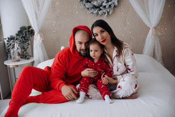 Family enjoys cozy time at home in festive pajamas during a holiday morning in the living room