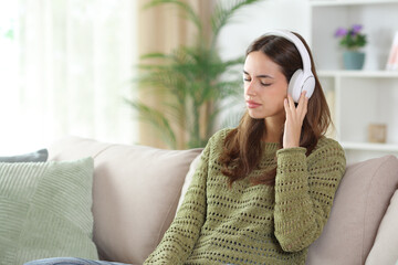 Woman in green at home listening and feeling music