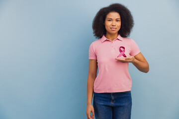 Black woman holding pink breast cancer awareness ribbon
