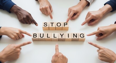 Group of diverse hands pointing at wooden blocks spelling STOP BULLYING on white table, concept of teamwork, awareness and unity against harassment, inclusion and social responsibility