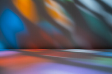 Stained glass light on wall. Light background for product presentation with colorful reflections and shadows on wall.	
