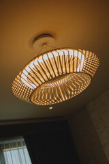 Warm ceiling light d&eacute;cor set within a wooden interior, creating a soft, dim lighting mood. Cozy and atmospheric design ideal for themes of interior d&eacute;cor, hospitality, relaxation, and ambient lighting