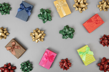 Set of colorful gift boxes and bows on a gray background. A greeting composition for holidays, Christmas, and Valentine's Day
