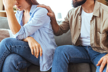 Couple Comforting Each Other on Sofa After Argument, With Supportive Hand on Shoulder