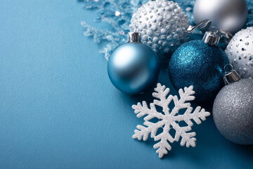 A refined set of ornaments and a snowflake decorates a cool blue background, creating a classy seasonal mood.