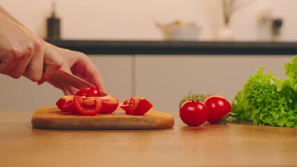 Close up shot person hands cutting with knife red tomatoes on wooden board for healthy food vegetable diet dinner. Happy woman preparing breakfast fresh green salad cherry tomato in the kitchen home
