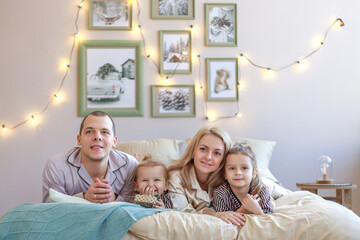 Fototapeta premium A happy family and pets in a bedroom at home on Christmas morning. New Year's.