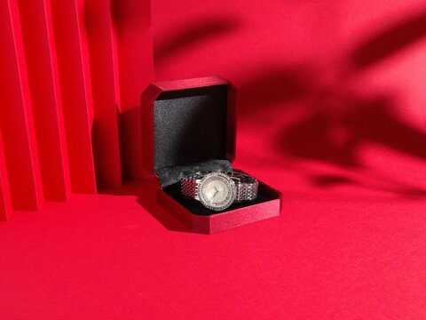 Reloj de lujo y elegante en estuche de regalo sobre fondo rojo &ndash; Concepto de San Valent&iacute;n y regalo rom&aacute;ntico