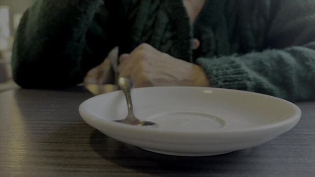 Older person drinking from a cup and saucer coffee or tea close up and slow motion 120fps UK 4K