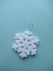 Snowflake Christmas tree toy on a blue background.