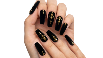 Hand with long black coffin nails decorated with golden studs and cross patterns showcasing a gothic or alternative fashion manicure trend