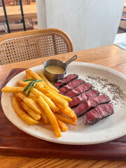 Beef steak with French fries on a wooden table