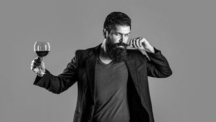 Man with a glass of red wine in his hands. Sommelier, degustator with glass of wine, winery, male winemaker. Beard man, bearded, sommelier tasting red wine