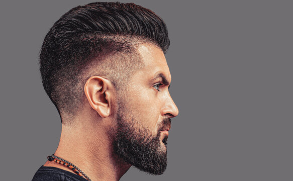 Side view bearded man isolated on gray background. Perfect beard. Closeup of young bearded man, stylish hairstyle, beard