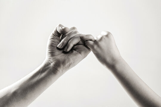 Peace between a man and a child, touch fingers with little fingers. Child hook little finger together. Two hands hook pinky fingers together to promise. Black and white