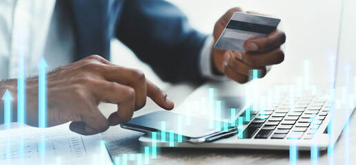 A person completes an online transaction using a smartphone and credit card while working at a tidy desk. The calm atmosphere supports focus on the digital payment process.