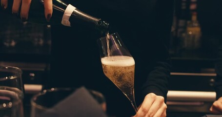 close-up view of woman's hand hold bottle pouring champagne into glass. serving alcoholic drink in restaurant. bartender pours champagne. air bubbles close up in glass. foam from sparkling wine - Powered by Adobe