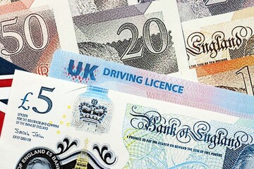 United Kingdom driving license card on UK British pounds money close up