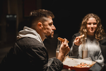 Friends enjoy late-night snacks at a cozy outdoor cafe in an urban setting while sharing laughter and stories