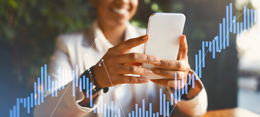 Engaged in financial analysis, a person smiles while using a smartphone. Graphs and charts in the background create a professional atmosphere in a modern setting, highlighting business tasks.