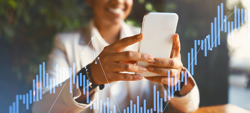 Engaged in financial analysis, a person smiles while using a smartphone. Graphs and charts in the background create a professional atmosphere in a modern setting, highlighting business tasks. - Powered by Adobe