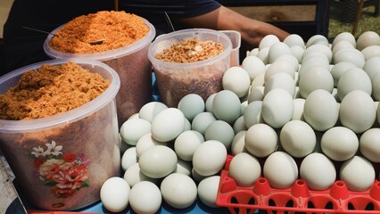 Ingredients for Indonesian Kerak Telor: white duck  eggs, dried coconut floss or serundeng, and fried shallots. Traditional Betawi street food preparation.