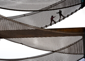 Interesting views of children climbing on the net platform in the children's playground