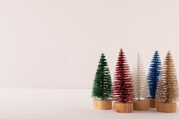 Colorful Christmas decoration trees on a white background. Holiday winter idea. Minimal concept.