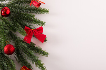 Christmas fir tree branches with red decoration isolated on a white background, minimal  Christmas flatlay idea. Holiday concept.