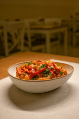Spicy Chicken Dish with Bell Peppers and Herbs in a Ceramic Bowl