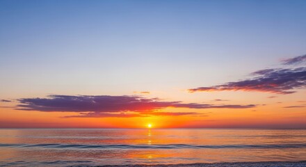 A serene beach scene with a vibrant sunset over the ocean.