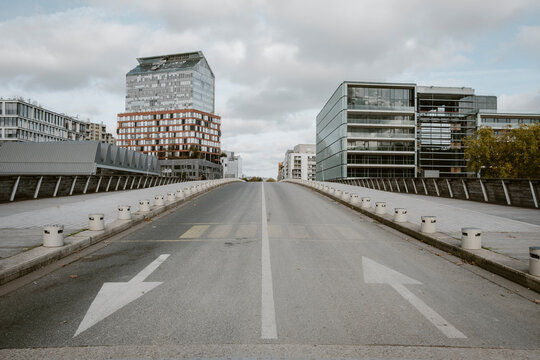 Paris architecture lines an empty urban street where city mobility meets modern exterior textures, revealing pavement patterns that enhance the road&rsquo;s quiet harmony