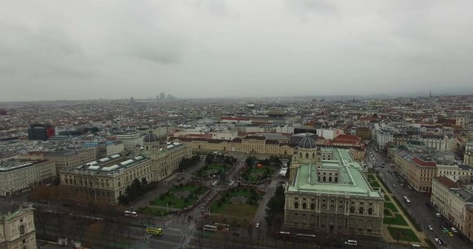 Drone footage capturing the massive scale of Vienna's Museum Quarter (Maria-Theresien-Platz) with the symmetrical Museum of Natural History and Museum of Art History under a dramatic