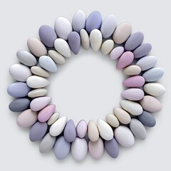 Circular arrangement of smooth, pastel-colored pebbles forming a ring on a neutral background