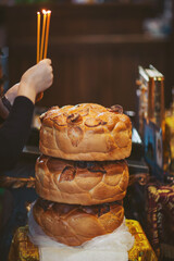 Celebration with lit candles and stacked bread at a local event in a festive setting during the evening