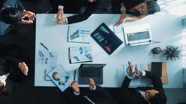 Top down aerial view of smart business team discuss about financial plan and finding solution. Group of diverse people working together and clapping hands to celebrate successful project. Directorate. - Powered by Adobe